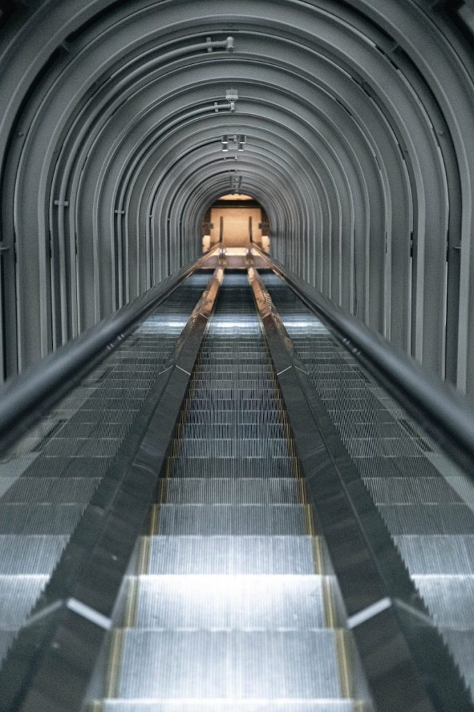Escalator leading into a futuristic metal tunnel